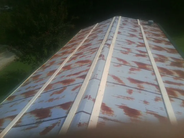 Rusted metal roof panels with new wood purlins before replacement — Storm Damage Roof Repair in Hahira by Roofing Brothers