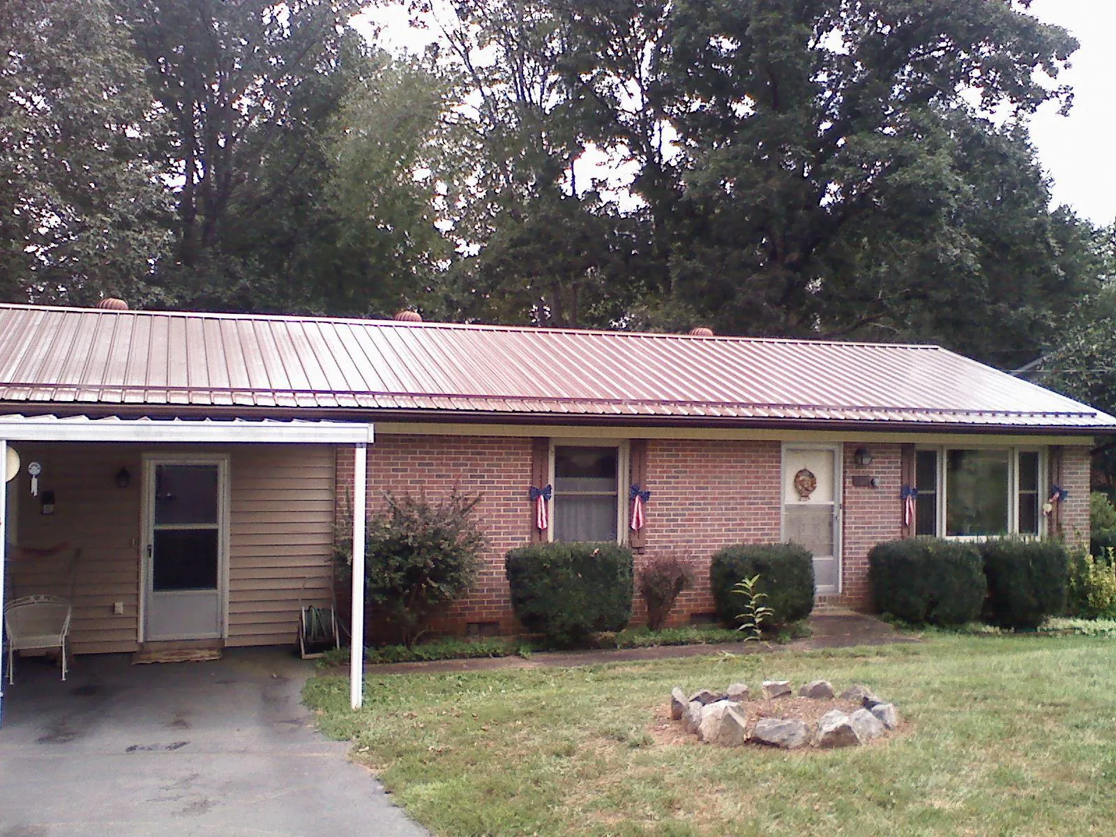 Bronze metal roof and carport on a brick ranch home — Roof Repair work by our crew in Hahira