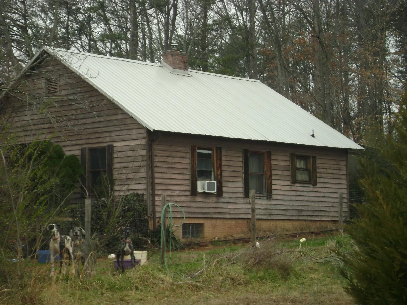 White metal roof on an old wood sided farmhouse, from a Metal Roof Installation job in Hahira